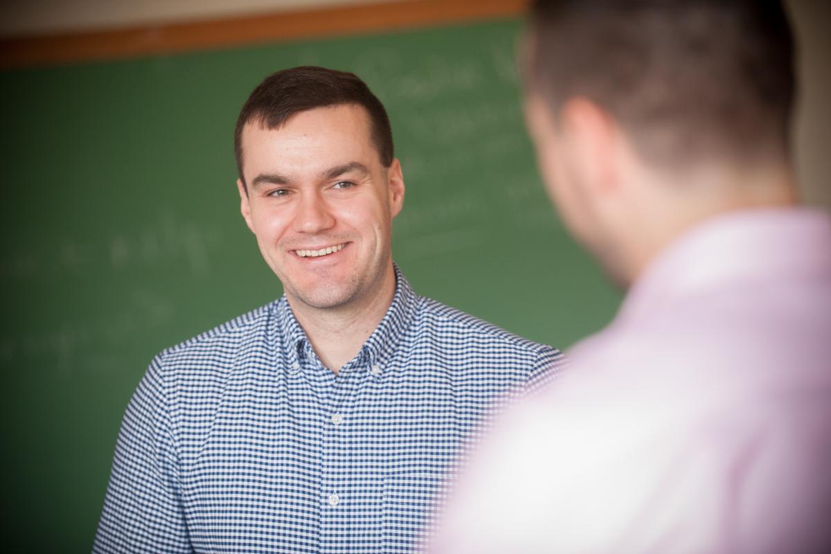 Male student smiling as he talks in the classroom