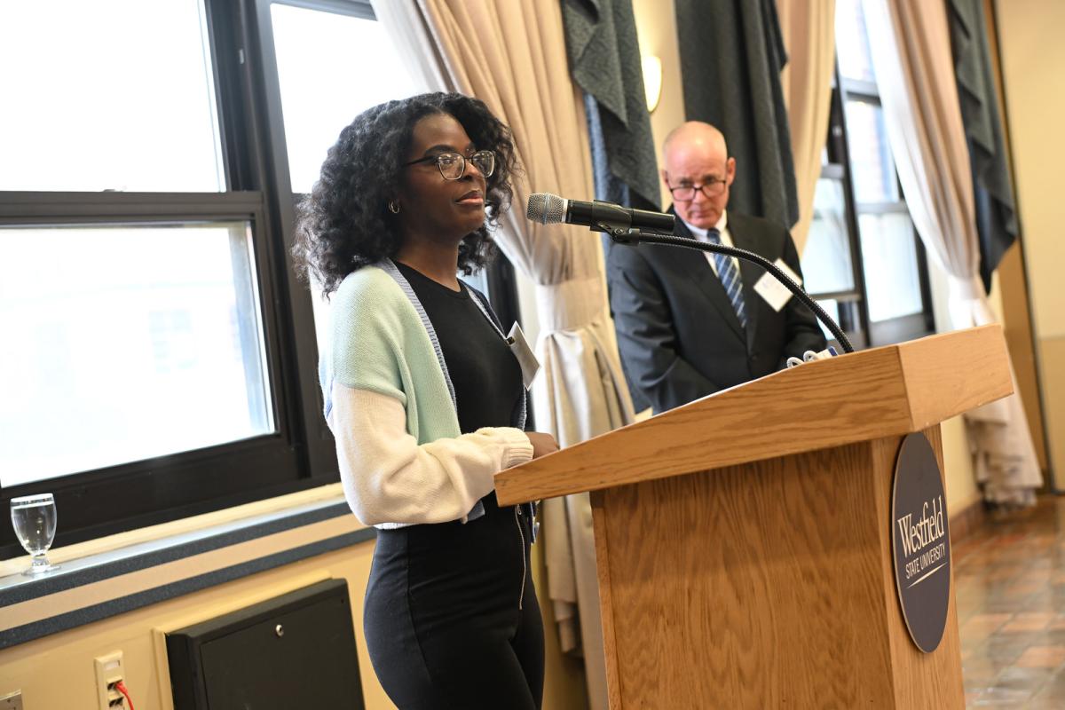 Student delivering a speech at a podium in front of an audience.
