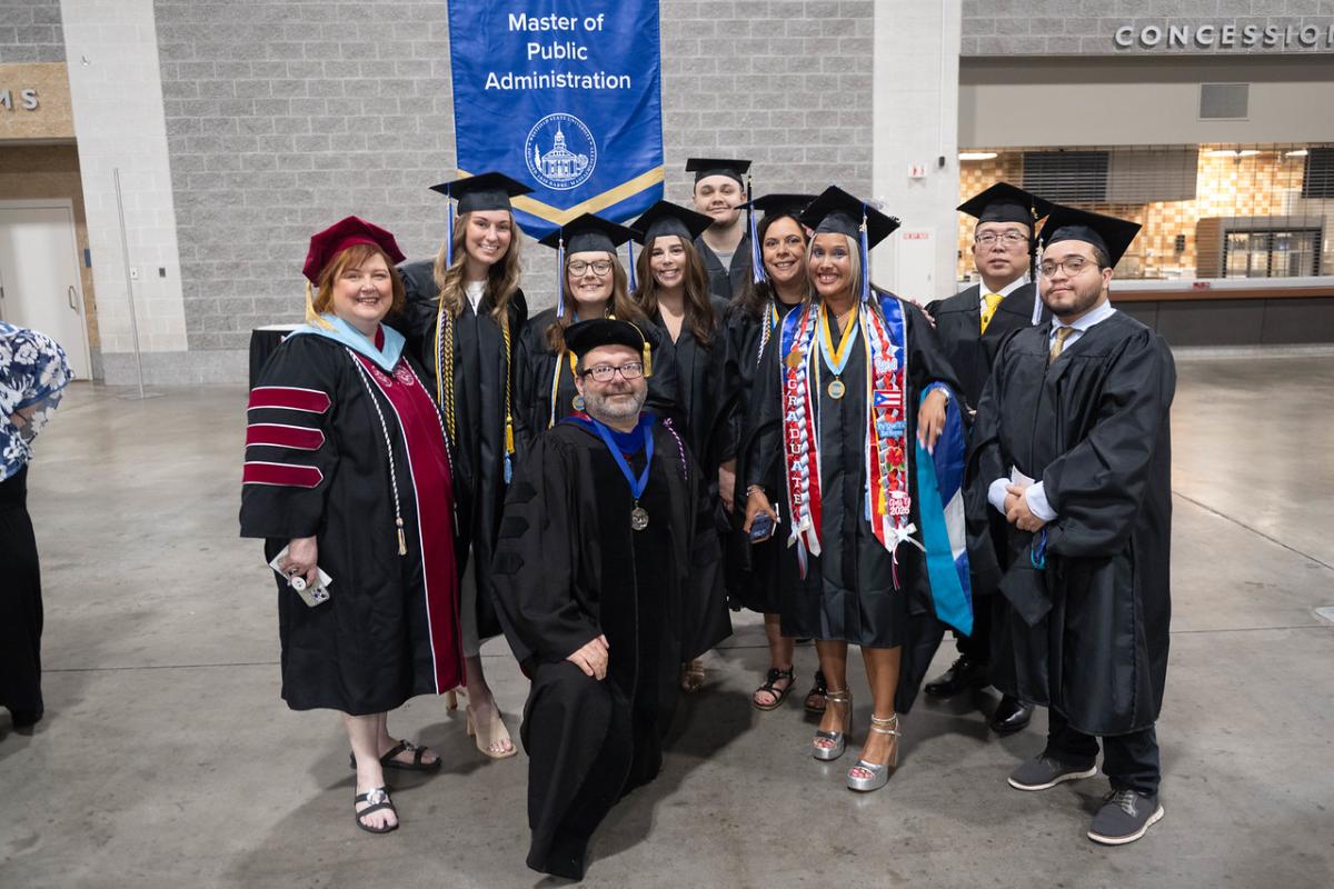 MPA students and faculty at graduate commencement wearing caps and gowns.