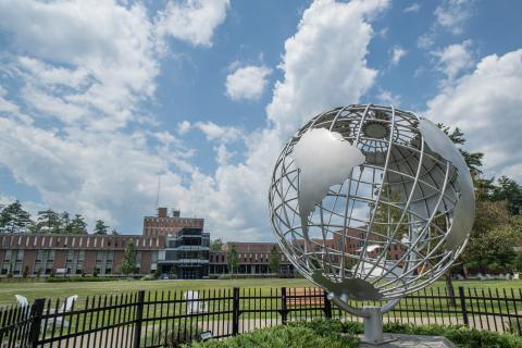 Globe sculpture with blue sky and clouds