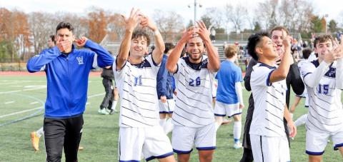 The Owls men's soccer team celebrating a game win by pointing to their ring finger, signaling their successful season.