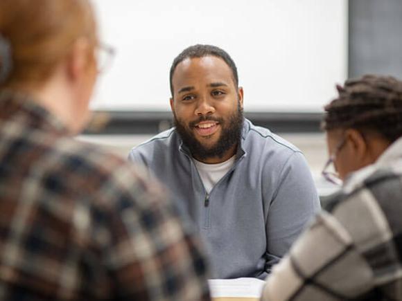 male student talking to other students in class