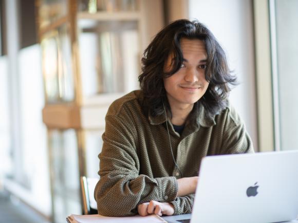 Ethnic and Gender Studies Student with laptop in library.