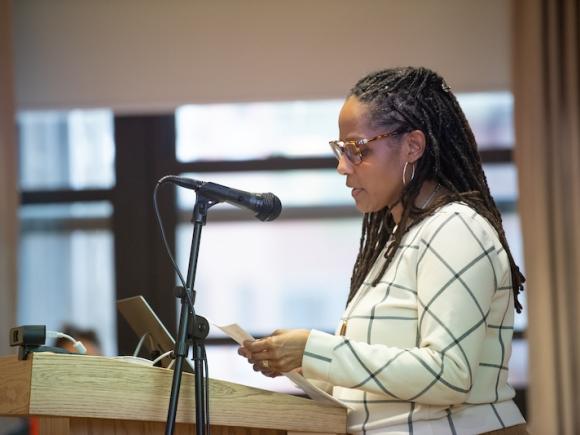 Dr. H. Zahra Caldwell, Chair and Associate Professor of Ethnic and Gender Studies, speaking at a podium for an event held in the Scanlon Banquet Hall that discussed violence against black and indigenous peoples.