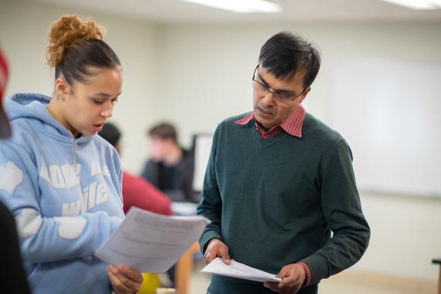 Student working with a professor in a chemistry class.