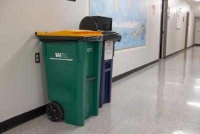 Yellow-lidded bins for single-stream recycling and tan /black circular cans for all other trash.