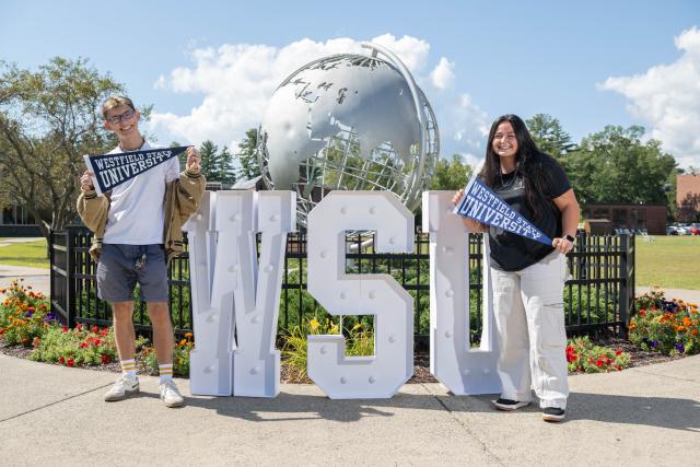 Students standing at the globe in front of the letters WSU